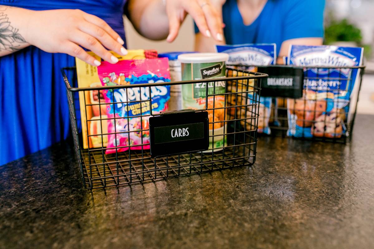 Assortment of colorful reusable food containers for lunch box arranged neatly on a wooden kitchen counter