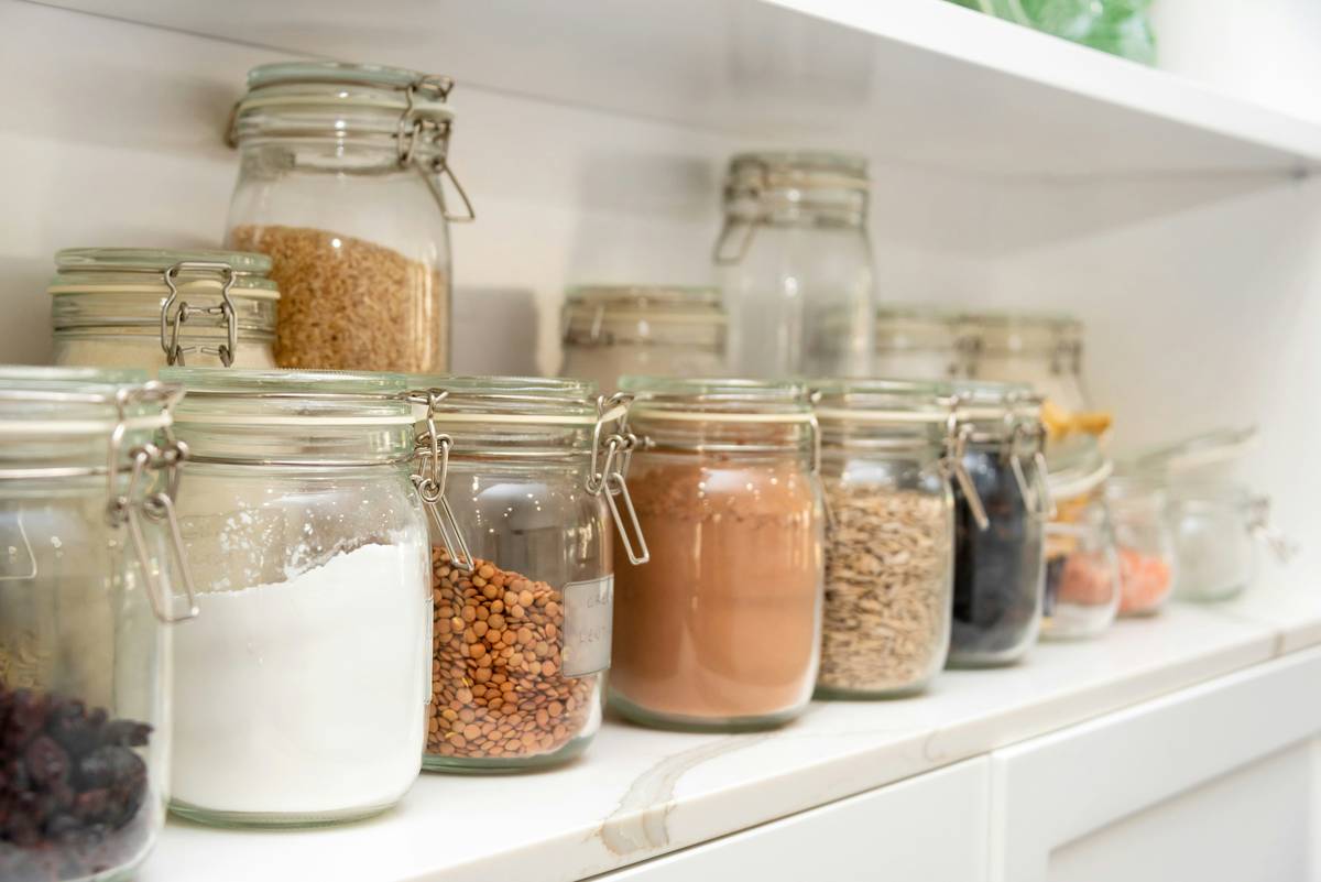 assorted eco friendly food storage containers on a kitchen counter with fresh fruits and vegetables
