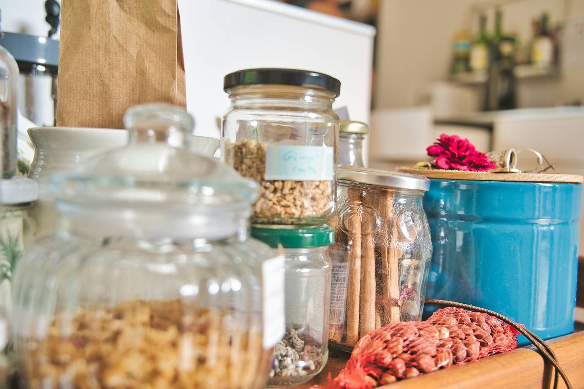 Assorted sustainable to go containers made of stainless steel, bamboo, and glass on a kitchen counter